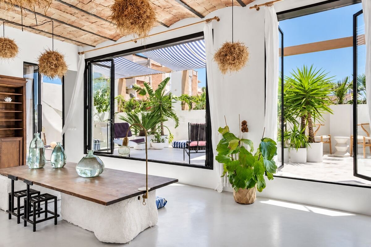 Salón con acceso directo a una terraza cubierta, techo de bóveda catalana y toldo de rayas